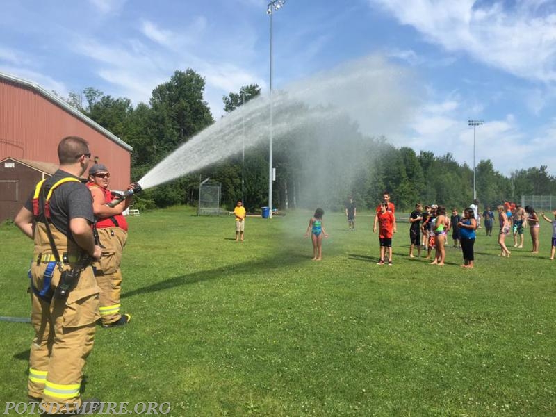 Firefighter J. McGregor and J. Lavoie cool off a few children at the Potsdam Rec Program on a nice summer day