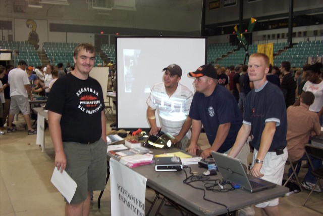 August 2004 - Potsdam Firefighters talk with prospective member Myles Farrell during the Clarkson University activities fair at Cheel Arena